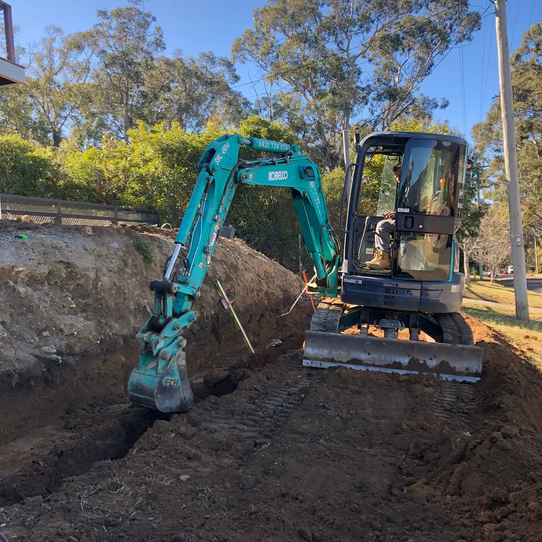 Excavator digging a trench on construction site.