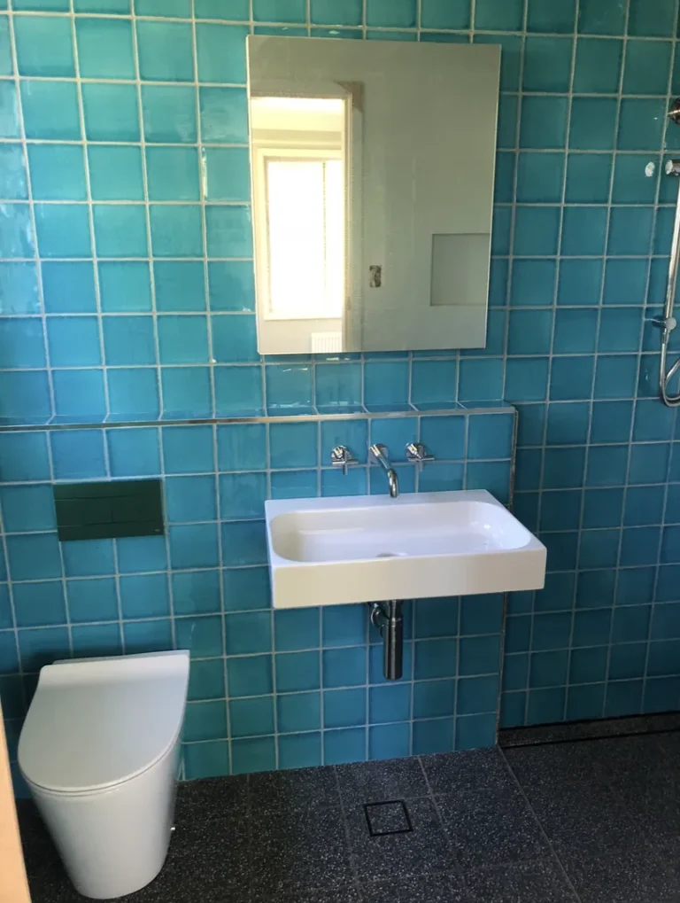 Modern bathroom with blue tiles and white fixtures