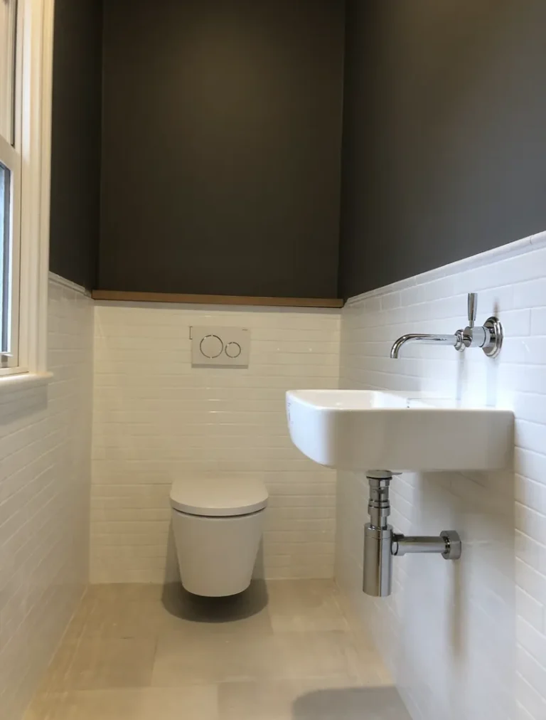 Modern bathroom with toilet and wall-mounted sink.
