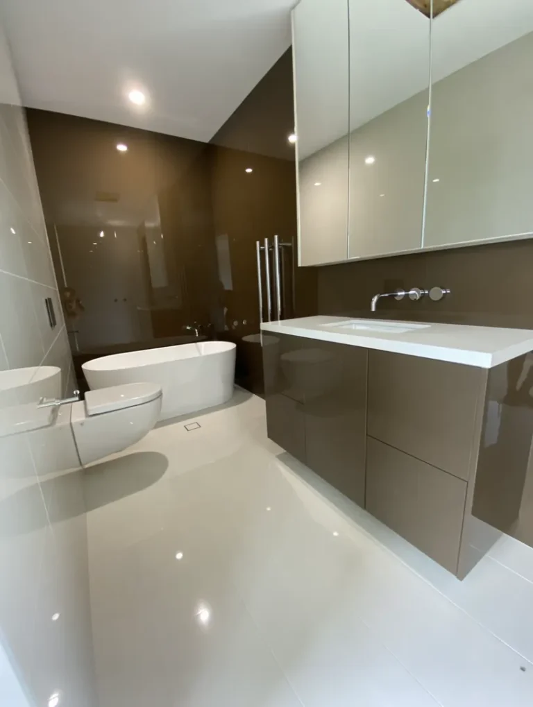 Modern bathroom with bathtub and floating toilet.