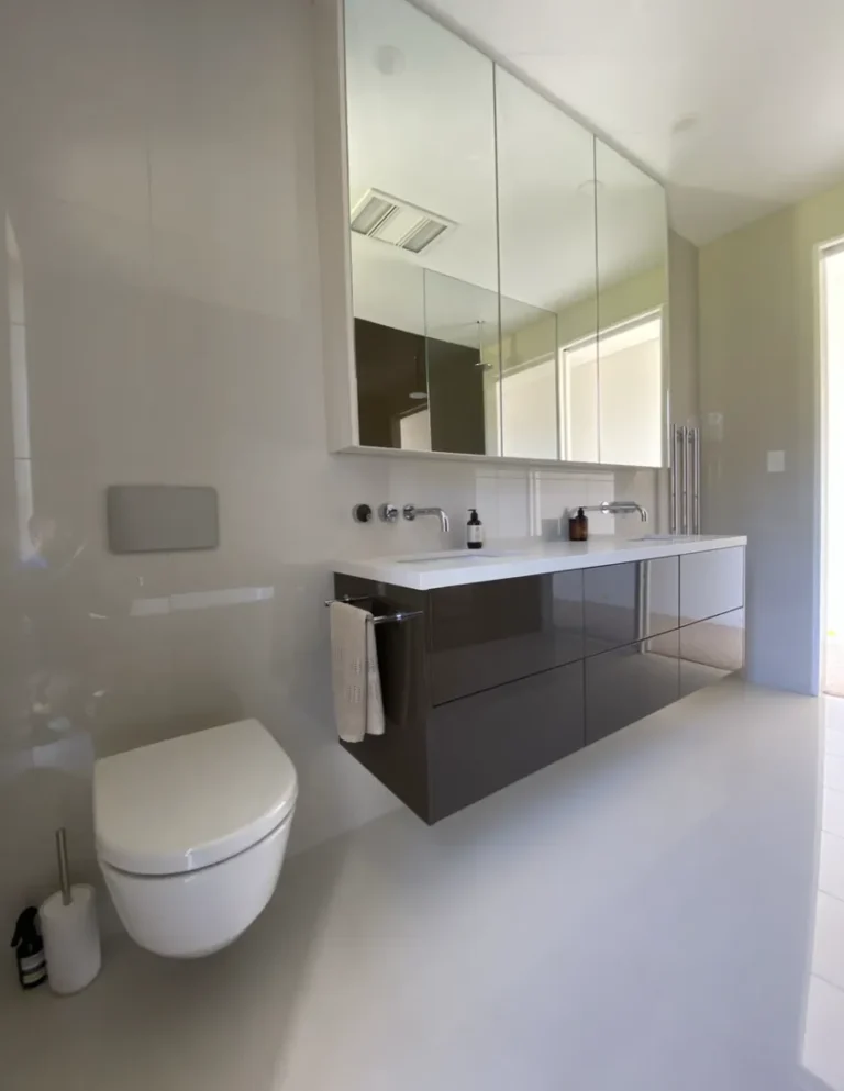 Modern bathroom with wall-mounted toilet and vanity.