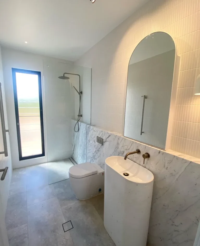 Modern bathroom with shower and marble sink.