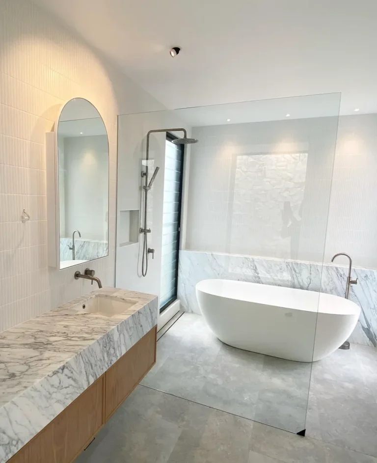 Modern bathroom with bathtub and marble sink.